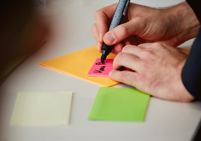 Mann schreibt auf Post-it