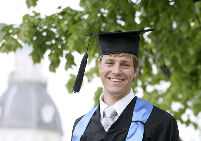 Alumni Andreas Reiser in a graduation cap and gown